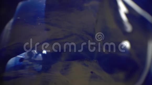 金属刮刀在玻璃上均匀地涂上蓝色和白色的油彩视频的预览图