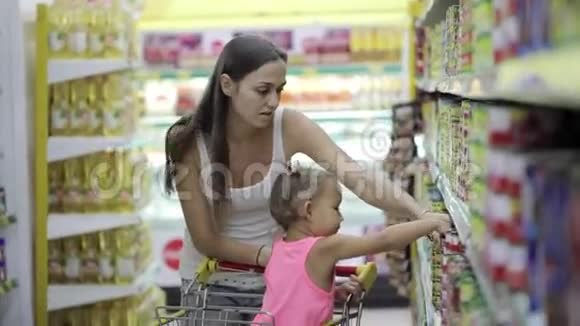 妈妈和小女儿在超市挑选罐头视频的预览图