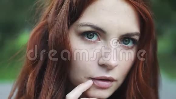 一位美丽的红发女孩的特写肖像她的眼睛富有表现力视频的预览图