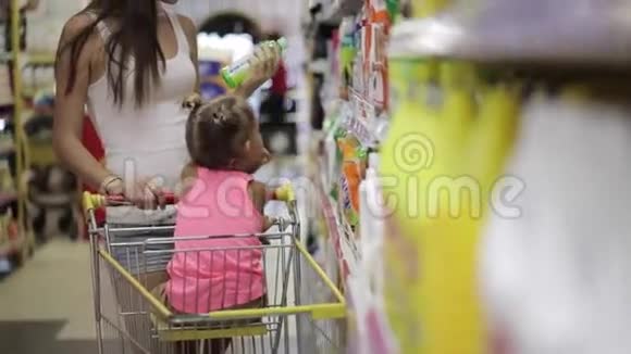 小女儿的年轻女性选择超市里的清洁剂视频的预览图