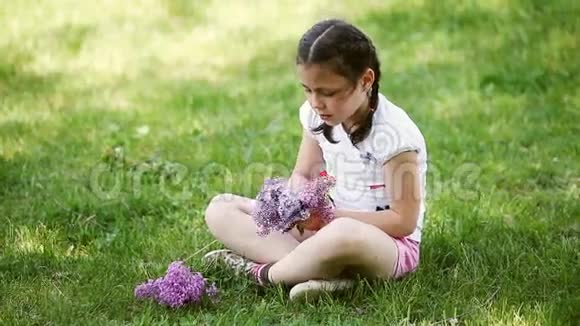 在草地上快乐的小女孩编织花圈视频的预览图