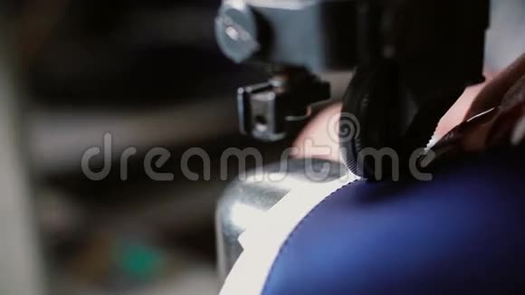 女人在缝纫机上做一个光滑的接缝工人为制鞋缝制皮革女士缝纫件在一起4K视频的预览图