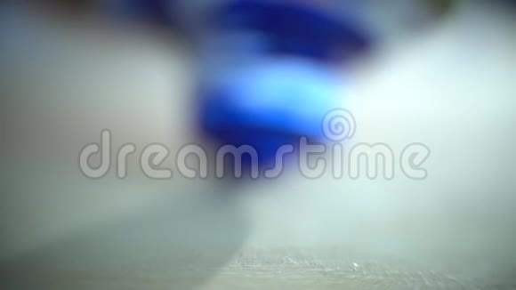 宏观拍摄白色郁金香挤压蓝色油漆慢慢涂抹在木制调色板上视频的预览图