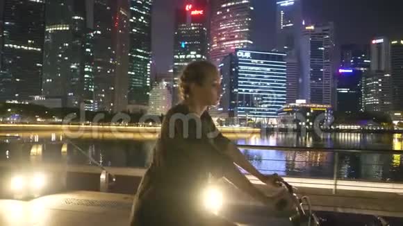 晚上骑自行车的快乐女人视频的预览图