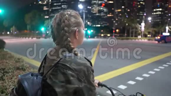 晚上骑自行车的快乐女人视频的预览图