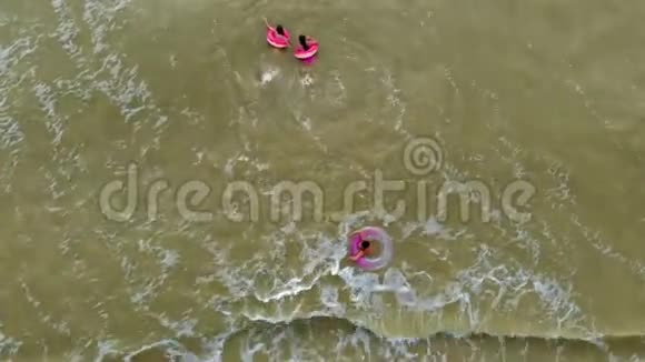 穿着橡皮圈的人在海里的波浪上游泳空中录像视频的预览图