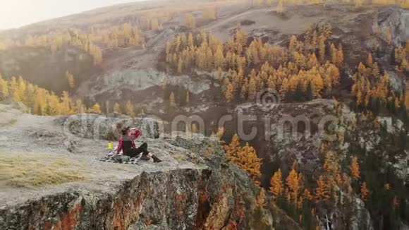 女人坐在高山上欣赏日落视频的预览图