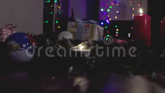 圣诞礼物在黑暗的房间里燃烧蜡烛和花环视频的预览图