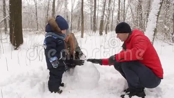一家人带着孩子在公园堆雪人视频的预览图