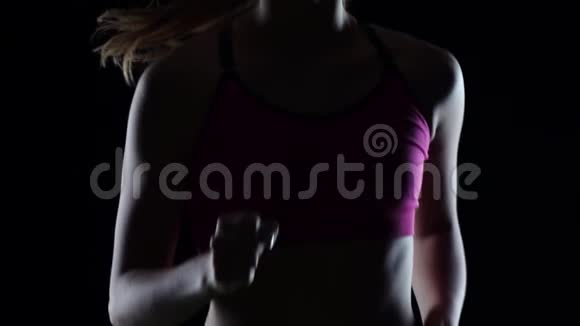 健身运动员在黑色背景下慢跑剪影慢动作关门视频的预览图