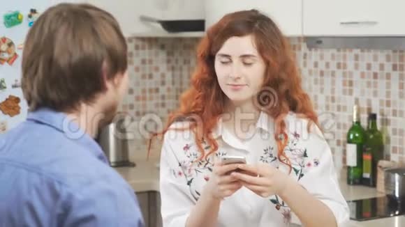 漂亮的女孩一头卷曲的红色头发带着电话一个男人在喝咖啡视频的预览图