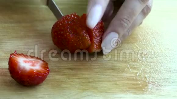 女性的手切出醇厚的草莓视频的预览图