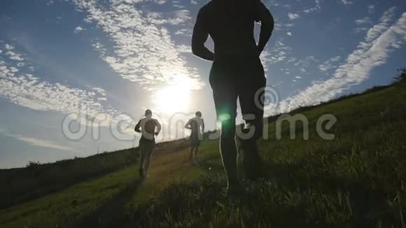 年轻人在蓝天背景下跑过青山男性运动员在日落时在大自然中慢跑体育运动员视频的预览图