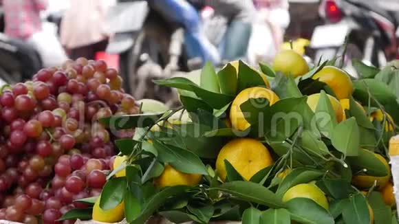 在当地的越南市场上在篮子里装上大量的橘子和葡萄视频的预览图