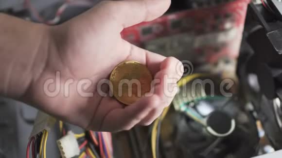 男性手中的比特币模糊背景下的电脑冷却器视频的预览图
