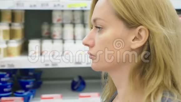 超市里的一个女人正从柜台边经过篮子4k特写视频的预览图