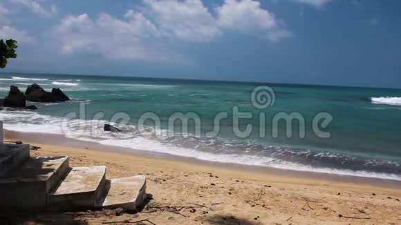 一小波清澈的热带海水撞击水泥台阶前的沙滩视频的预览图