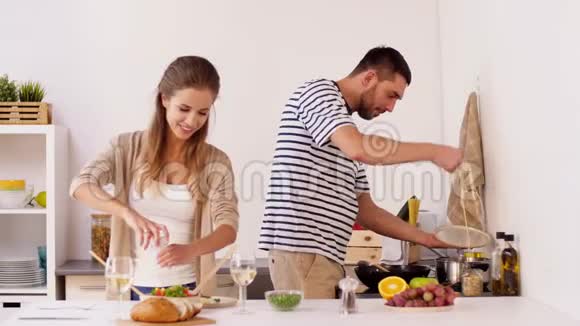快乐的一对夫妇在家做饭和供应食物视频的预览图