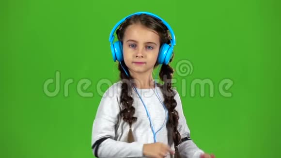 宝贝在耳机里听音乐绿色屏幕慢动作视频的预览图