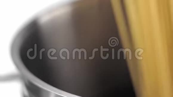 一个厨师把一个意大利面放在白色背景的钢锅里视频的预览图