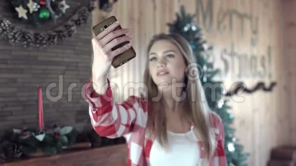 在圣诞树前自拍的女人视频的预览图