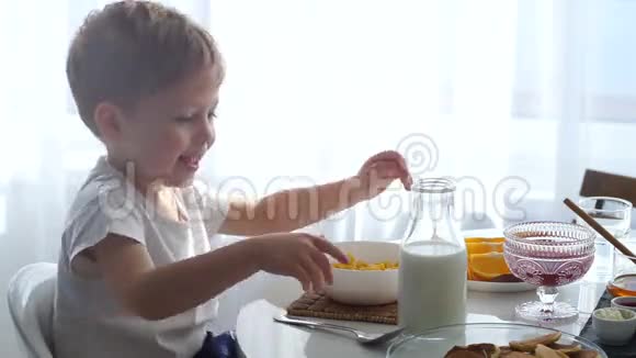 男孩把牛奶倒进一碗玉米片里这个男孩正在做早餐视频的预览图