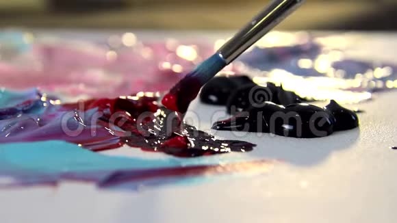 艺术家将不同颜色的丙烯酸涂料与画笔混合绘制绘制图片的颜色准备视频的预览图