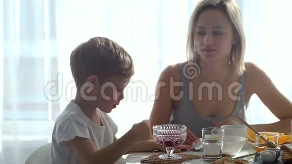 女孩和可爱的男孩吃早餐吃烤面包和煎饼视频的预览图