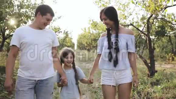 父母在大自然中与欢笑的女孩散步视频的预览图