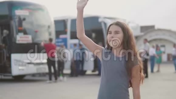 小女孩挥手在汽车站慢动作视频离开告别少女告别少女视频的预览图