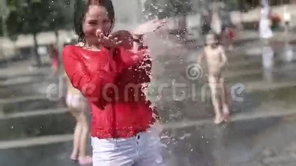 年轻漂亮的女孩站在喷泉里笑视频的预览图