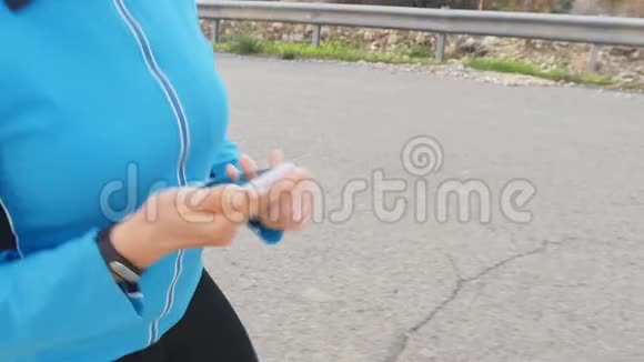 女跑运动员使用她的智能手表视频的预览图