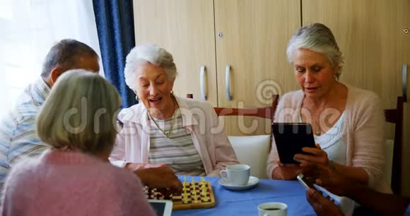 老年人在下棋时使用手机和数码平板电脑视频的预览图
