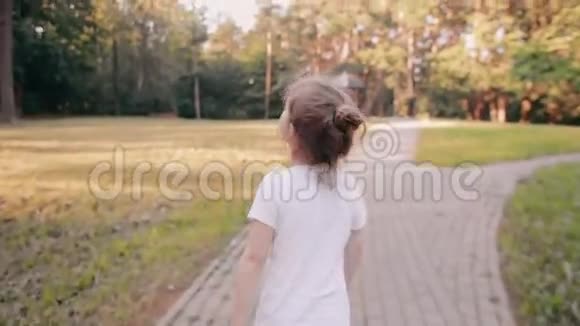 小女孩在公园的路上散步一束美丽的头发在阳光下闪闪发光慢影后景视频的预览图