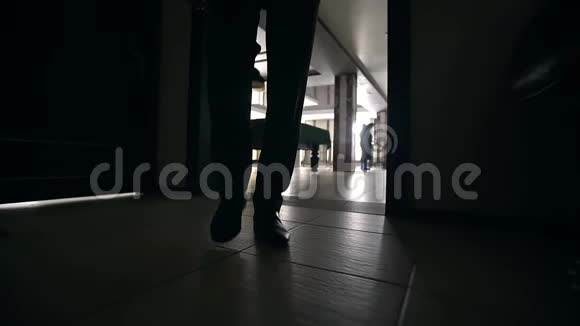一位衣着时髦的商人走着黑暗的走廊视频的预览图