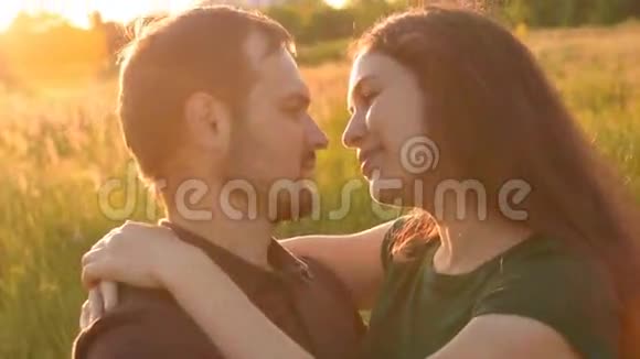 情侣们在日落时在公园里散步时互相摸鼻子视频的预览图