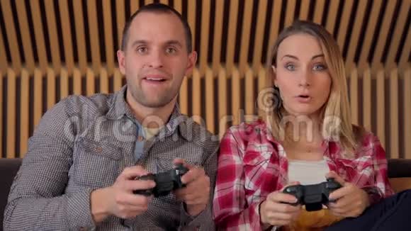快乐夫妻在沙发上玩电子游戏视频的预览图