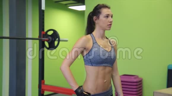 年轻的混合种族运动女子模型与完美的肌肉身体在健身房摆姿势视频的预览图