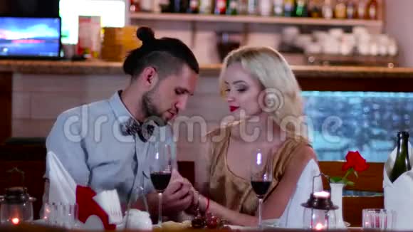 一对年轻的恋人在咖啡馆里浪漫的约会温柔的吻迷人的眼睛一个美丽的年轻女人浪漫的视频的预览图