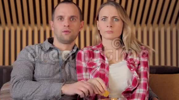 一对夫妇在电视上吃零食看恐怖电影斯特迪卡姆拍摄视频的预览图