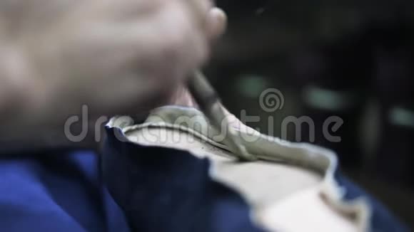 鞋匠把胶水涂在女人的鞋底上视频的预览图