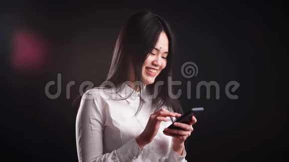 年轻的亚洲女人使用智能手机视频的预览图