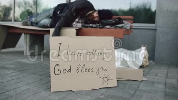 迷路的流浪汉睡在城市大街的长椅上视频的预览图