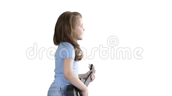 可爱的小女孩在白色背景上的四弦琴上玩耍边走边唱视频的预览图