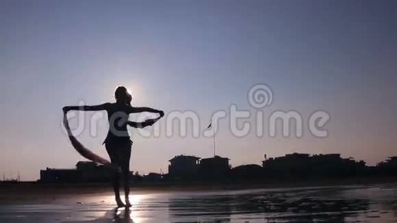 日落时分女人带着围巾旋转视频的预览图