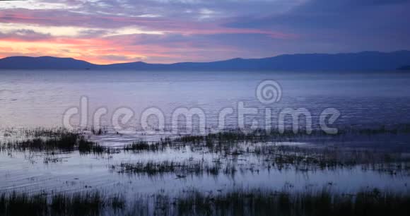 美丽的涟漪水背景在黄昏湖畔的孤寂中放松视频的预览图