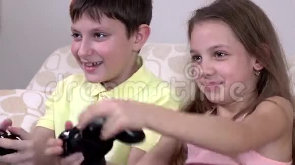 快乐的哥哥姐姐在家里的沙发上玩电子游戏视频的预览图