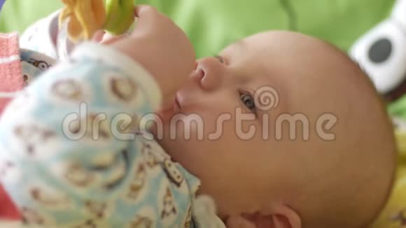 快乐的新生婴儿在五颜六色的床上打哈欠特写婴儿环顾四周然后微笑关爱的概念视频的预览图