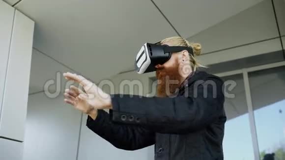 年轻的大胡子男子使用虚拟现实耳机360虚拟现实体验步行在城市街道户外视频的预览图