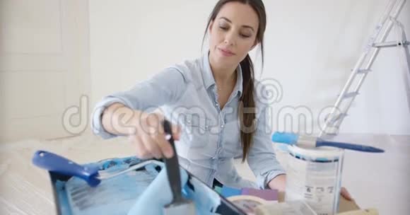 一个微笑的年轻女人在检查蓝色的油漆视频的预览图